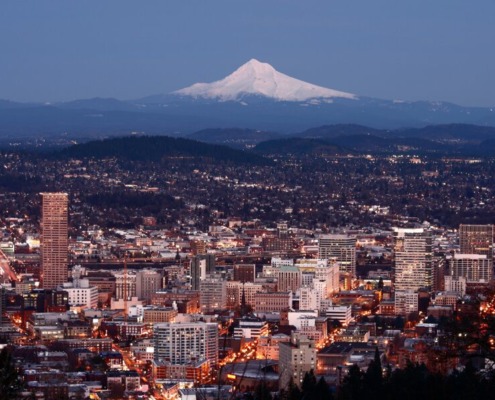 City lights of Portland, Oregon with Mount Hood in the distance.