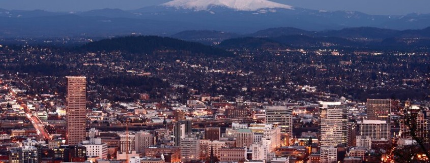 City lights of Portland, Oregon with Mount Hood in the distance.