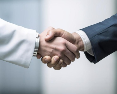 Image of two people shaking hands, but it's just their hands and the rest is off camera.